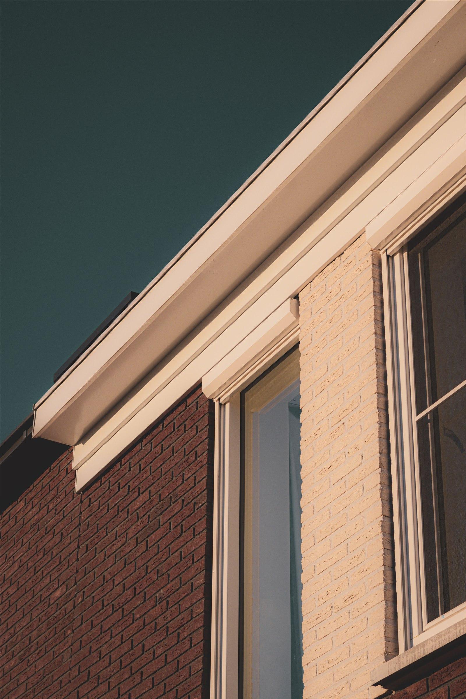 Sunlit brick home exterior with crisp windows and roofline