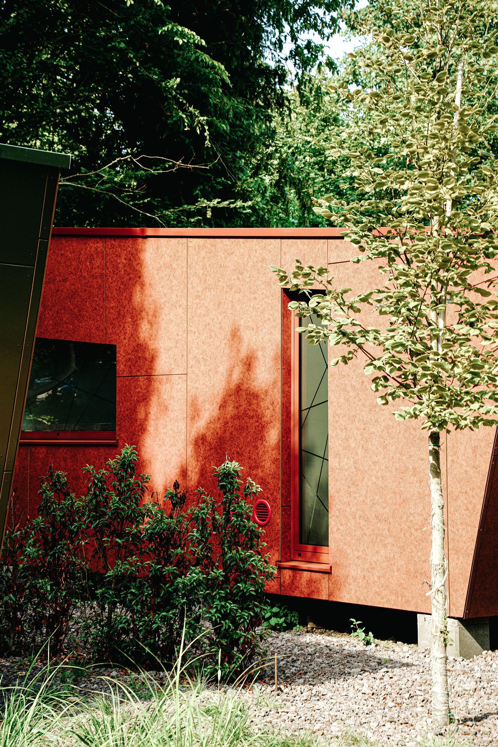Compact contemporary home with a rust-toned exterior among trees